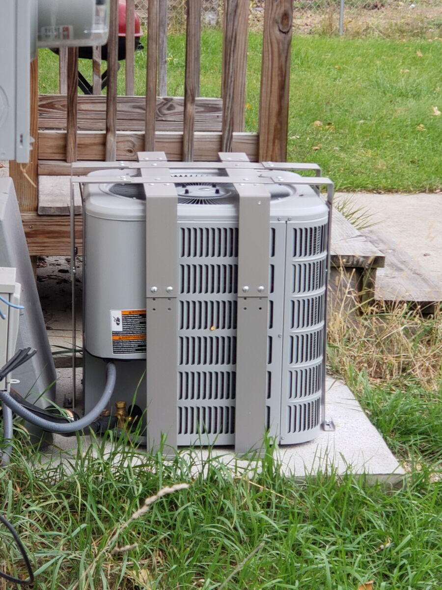 AC Bandit cage protecting a condenser unit mounted on a concrete pad
